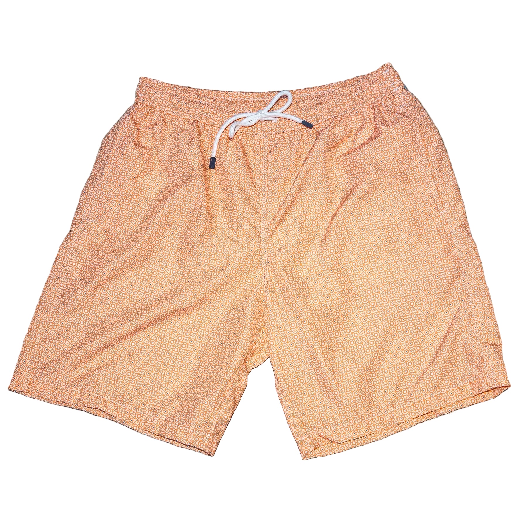 Orange shorts with a white drawstring on a gray concrete surface