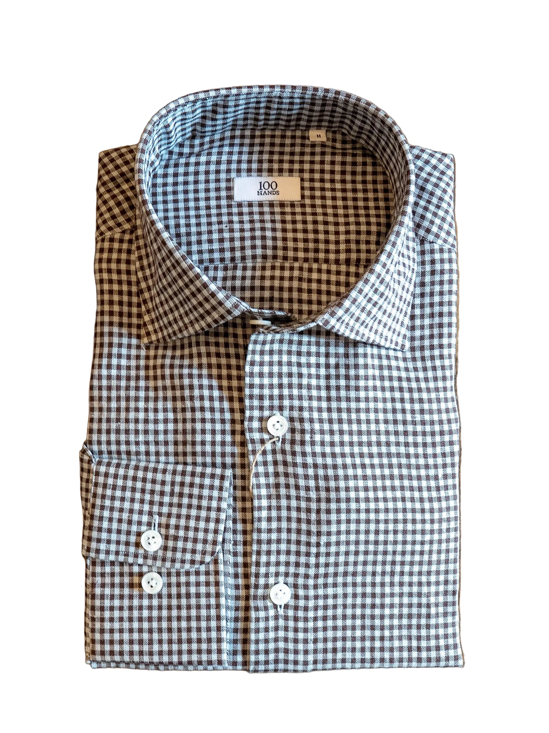 Folded checkered shirt with a visible label on a wooden surface