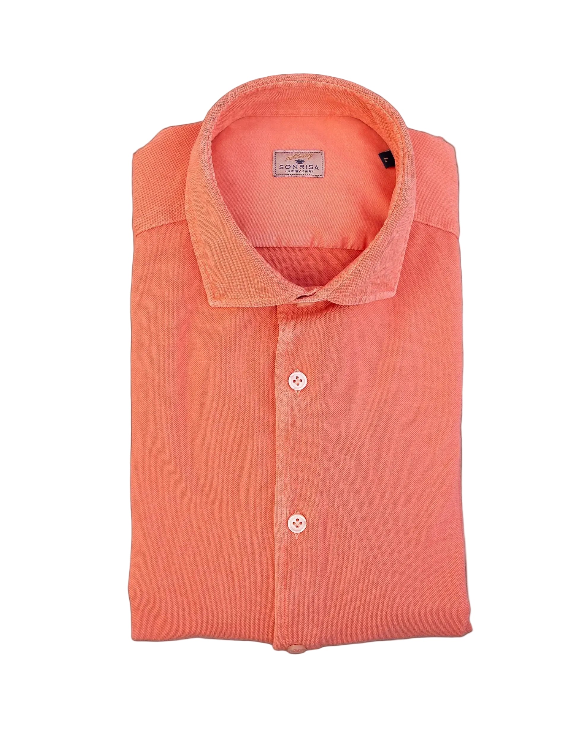 Folded orange shirt on a stone surface