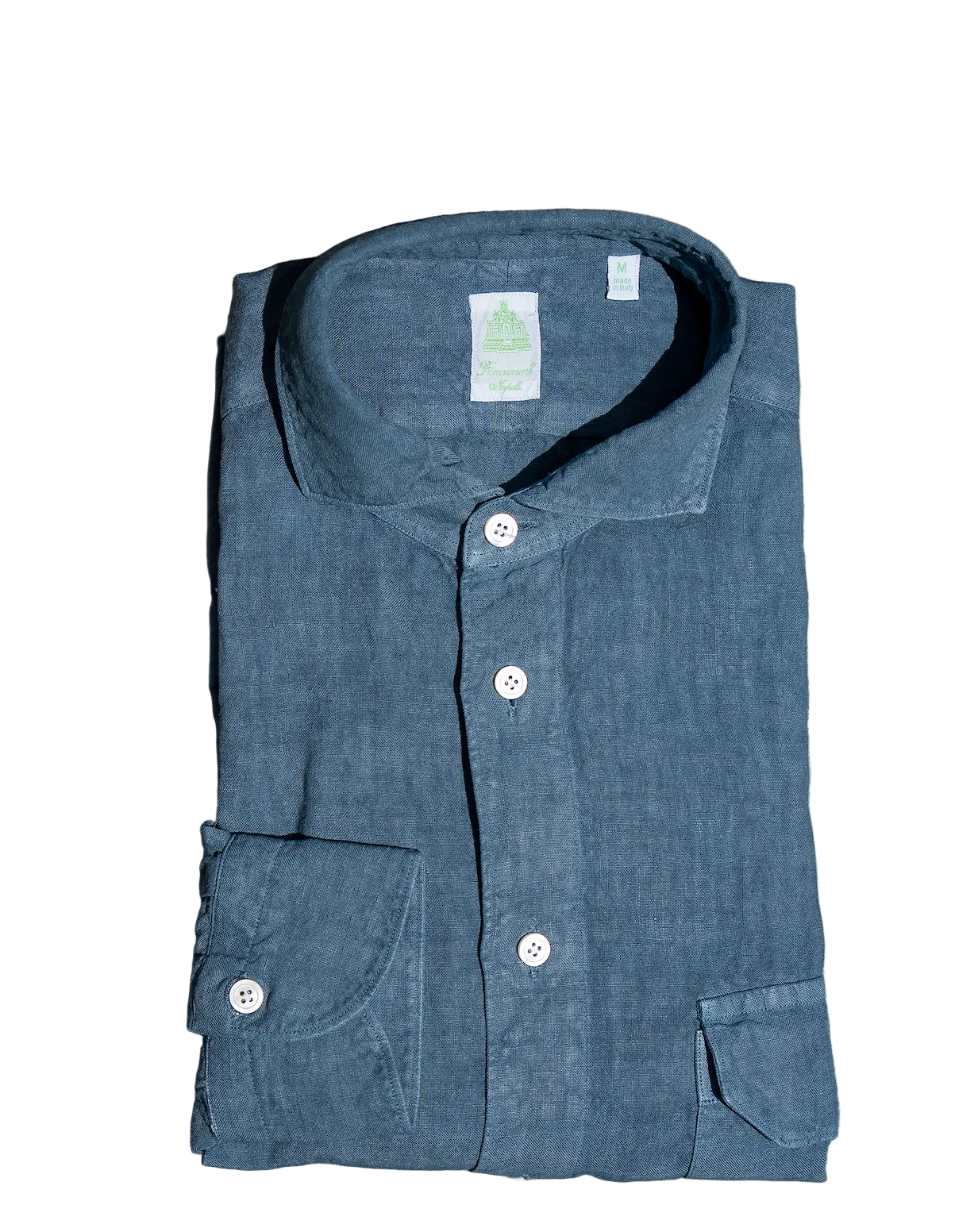 Folded blue shirt with a label on a stone surface